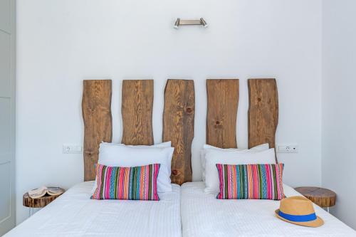 a bed with a headboard and two pillows at Cape Mykonos in Mýkonos City