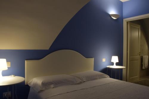 a blue bedroom with a bed and two lamps at Residenza Cavour in Acireale