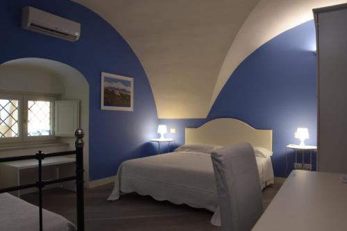a bedroom with two beds and a blue wall at Residenza Cavour in Acireale