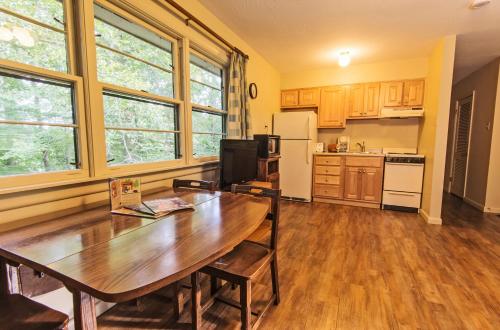 a kitchen with a wooden table and a wooden floor at Rough River Dam State Resort Park in Fentress McMahan