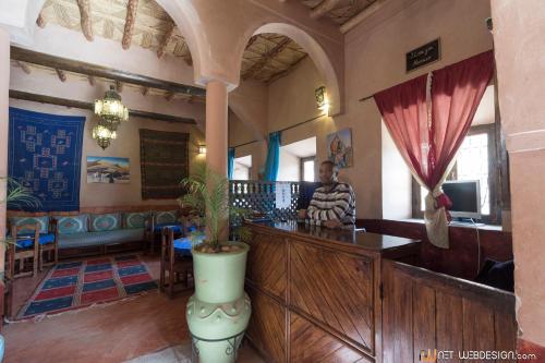 a man sitting at a bar in a restaurant at Kasbah Ounila in Aït Ben Haddou