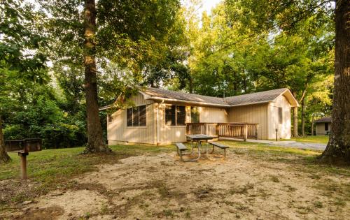 a house with a picnic table in front of it at Rough River Dam State Resort Park in Fentress McMahan