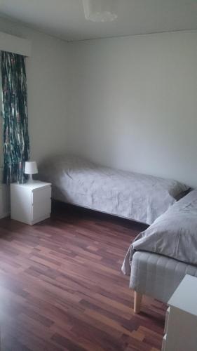 a bedroom with a bed and a wooden floor at Kotipaljakka in Kotila