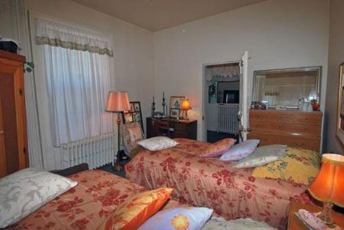 a bedroom with two beds and a window at Sommerville Court Motel Bed & Breakfast in Lucknow