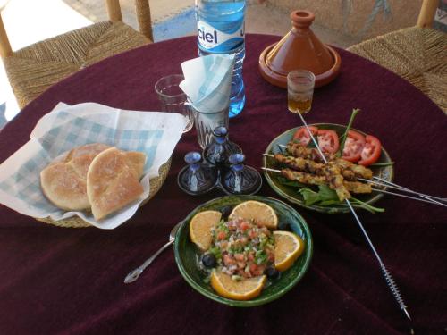 a purple table with two plates of food and bread at Ecolodge du Draa in Ouled Otmane