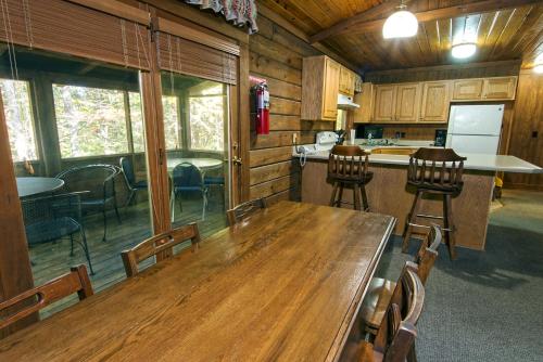 a kitchen and dining room with a wooden table and chairs at Lake Barkley State Resort Park in Cadiz