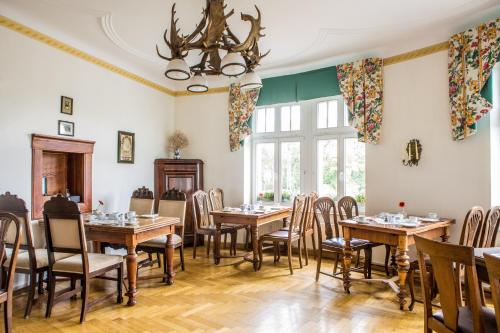 une salle à manger avec des tables et des chaises en bois dans l'établissement Jahrhunderthotel Leipzig, à Leipzig