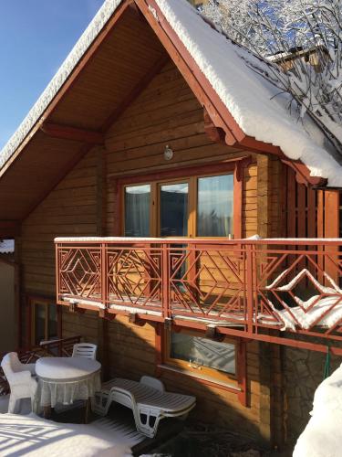 a log cabin with a balcony and a table and chairs at Villa Kaiser in Lviv