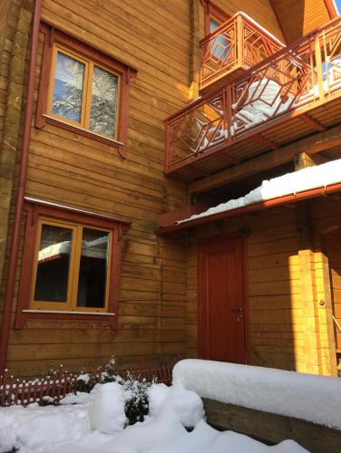 a wooden house with snow on the front of it at Villa Kaiser in Lviv