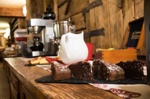 a group of brownies on a black plate with a pitcher at Hotel Meublé Mon Rêve in Breuil-Cervinia
