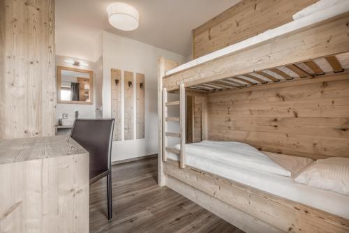 a bedroom with two bunk beds and a desk at Haus Spielbichl in San Lorenzo di Sebato