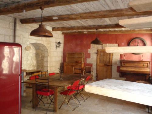 una sala da pranzo con tavolo, sedie e pianoforte di Le Lapin Blanc a Saint-Rémy-de-Provence