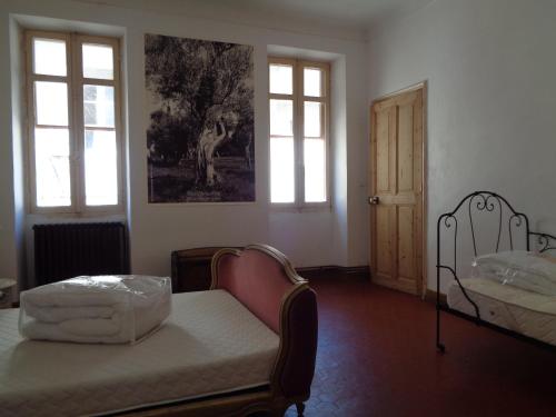 Cette chambre comprend un lit, 2 fenêtres et une porte. dans l'établissement Le Lapin Blanc, à Saint-Rémy-de-Provence