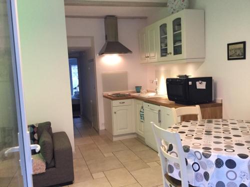 une cuisine et une salle à manger avec une table et des chaises dans l'établissement Maison proche du port, à Cancale