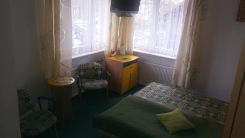 グディニャにあるNaturalne Cuda i Przebudzenie Mocyのベッド1台、椅子、窓が備わる小さな客室です。