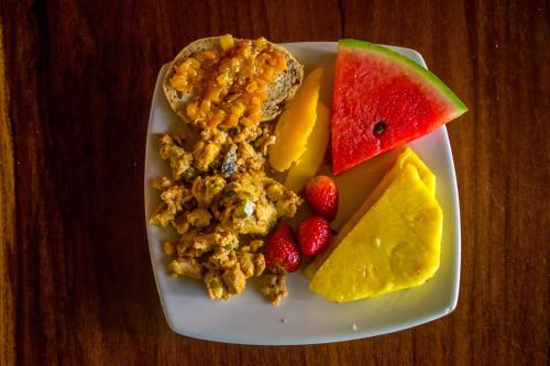 een bord ontbijtproducten met fruit en noten bij The Goddess Garden Eco-Resort in Cahuita