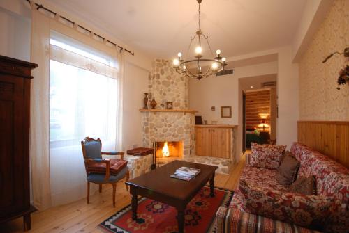 a living room with a couch and a fireplace at Vaela Hotel Cultural Resort in Elatochori