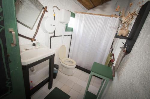 Baño pequeño con aseo y lavamanos en Hostel Albatros, en Cabo Polonio