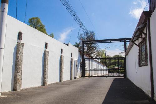 a white wall with a gate in a building at Terida Airport B&B in Alajuela City