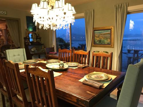 a dining room table with chairs and a chandelier at Mermaid's Muse Bed and Breakfast in Brookings