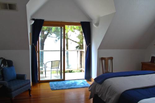 a bedroom with a bed and a window and a chair at Lost Whale Inn in Trinidad