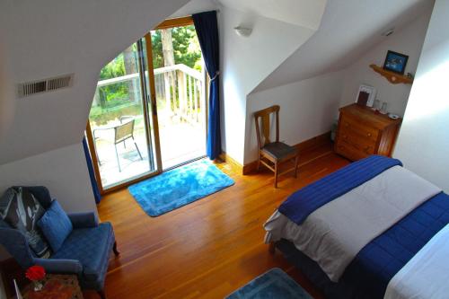 a bedroom with a bed and a chair and a window at Lost Whale Inn in Trinidad