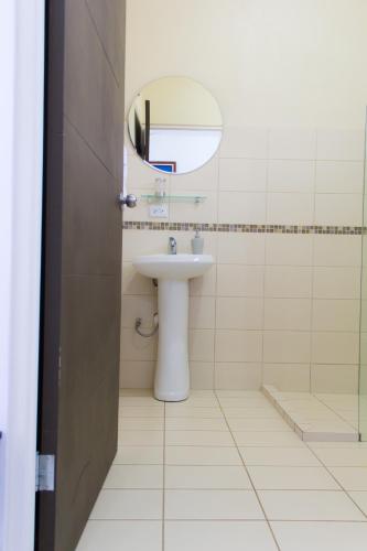 a bathroom with a sink and a mirror at Terida Airport B&B in Alajuela City