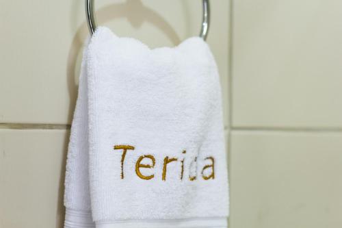 a towel with the word ternia hanging on a wall at Terida Airport B&B in Alajuela City