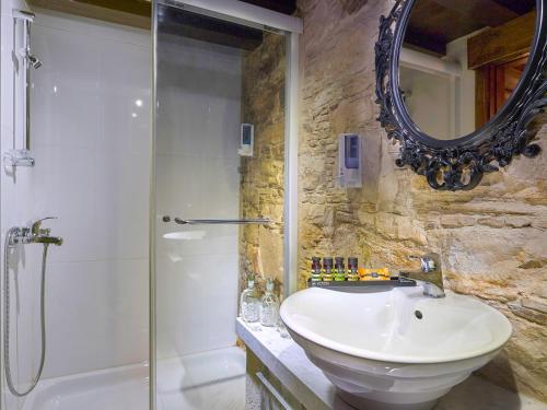 a bathroom with a sink and a shower and a mirror at Oinoessa Traditional Boutique Guest Houses in Lofou
