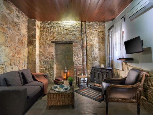 a living room with a couch and a fireplace at Oinoessa Traditional Boutique Guest Houses in Lofou