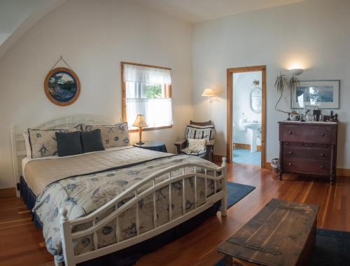 a bedroom with a bed and a dresser and a mirror at Lost Whale Inn in Trinidad