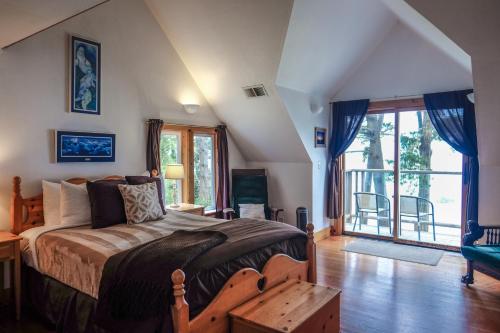 um quarto com uma cama e uma grande janela em Lost Whale Inn em Trinidad