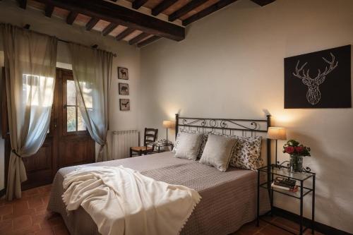 a bedroom with a bed and a window at In Toscana Camere in Monticchiello