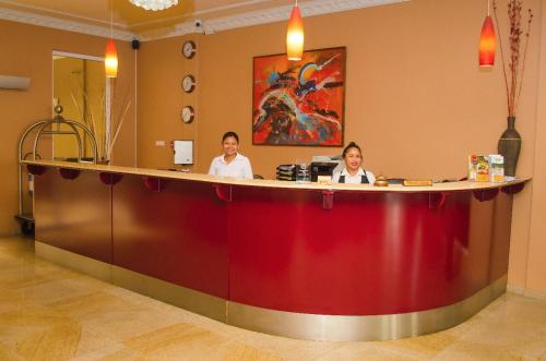 パラマリボにあるSheva Hotelの三人の女性が部屋のカウンターに座っている
