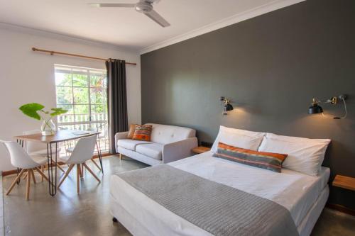 a bedroom with a bed and a table and a chair at Motel Nomad in Cairns