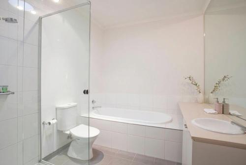 een badkamer met een toilet, een douche en een wastafel bij Torquay Golf Retreats - Pool, Beach, Tennis, Golf in Torquay