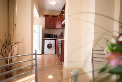 a kitchen with a table and a washer and dryer at Complex Apolon in Nesebar