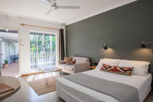 a bedroom with a bed and a living room at Motel Nomad in Cairns