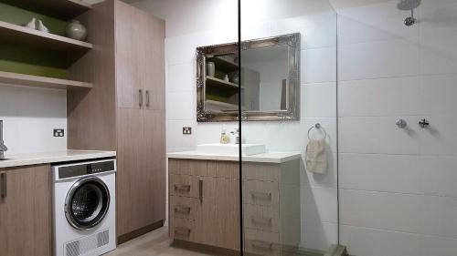 a bathroom with a sink and a washing machine at Equestrian Farm Stay in One Tree Hill