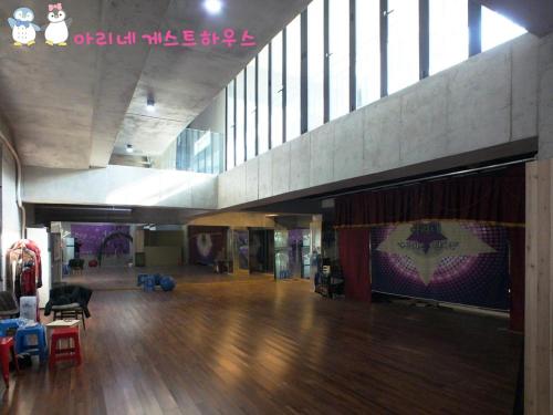a large room with a wooden floor and a stage at Ariene Guesthouse in Gwangju