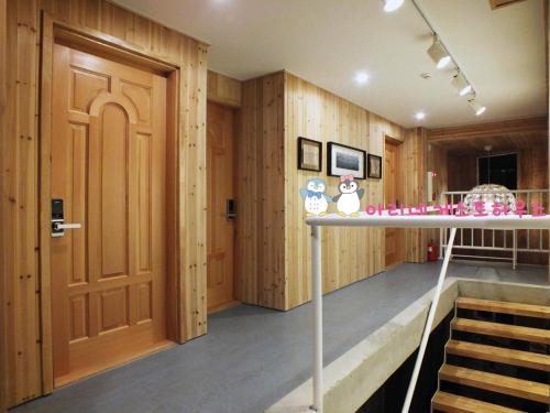 a room with wooden walls and a wooden door at Ariene Guesthouse in Gwangju