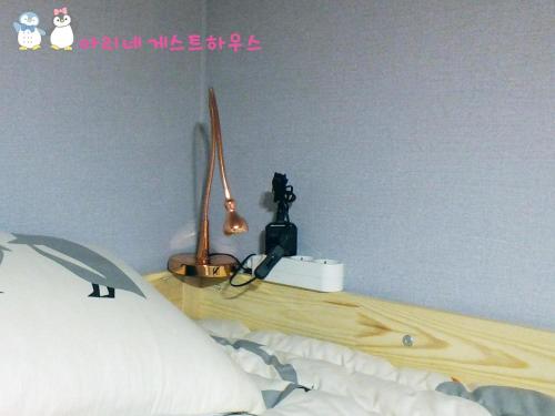 a bedroom with a bed and a desk with a lamp at Ariene Guesthouse in Gwangju