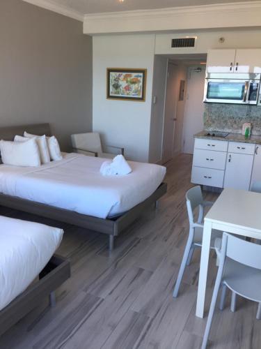 a room with two beds and a table and a kitchen at Ocean Front Units at Miami Beach in Miami Beach