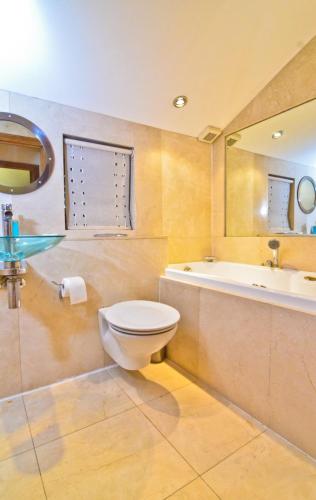 a bathroom with a toilet and a tub and a sink at Thames View House Surrey Quays in London