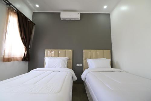 2 Betten nebeneinander in einem Zimmer in der Unterkunft Diyar Villas Puncak K3/2 in Puncak