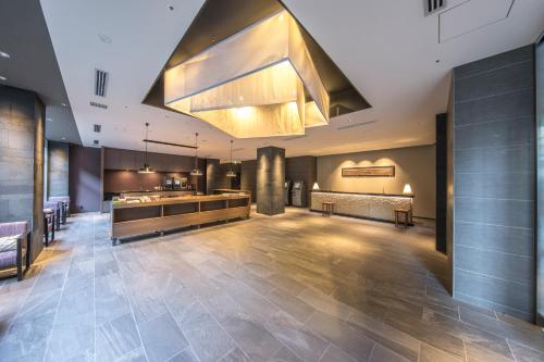 a large lobby with a largeandelier hanging from the ceiling at Tokyu Stay Kyoto Sanjo-Karasuma in Kyoto