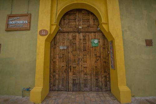 drewniane drzwi z łukiem w budynku w obiekcie Rossco Backpackers Hostel w mieście San Cristóbal de Las Casas