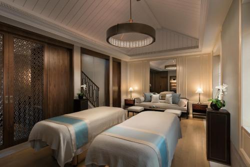 a hotel room with two beds and a couch at Capella Shanghai, Jian Ye Li in Shanghai