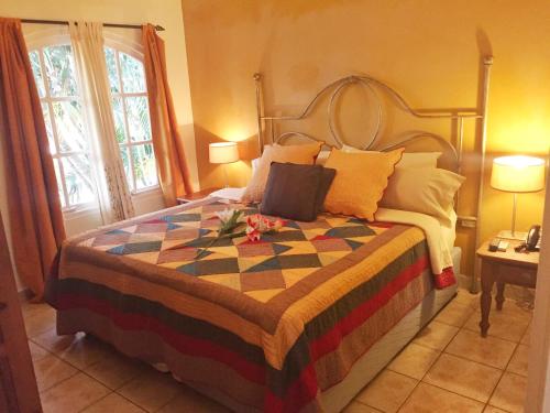 um quarto com uma cama grande e uma colcha colorida em Wacamaya em Palm-Eagle Beach