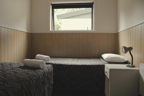 a bedroom with a bed with two pillows and a window at Geraldine TOP 10 Holiday Park in Geraldine